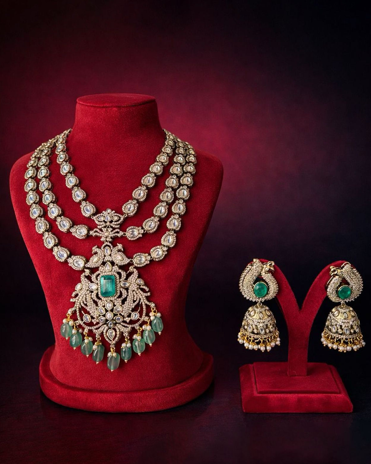 Elegant multi-layered Kundan-style necklace featuring intricate gold detailing, oval-cut white stones, a central green gemstone pendant, and cascading green teardrop beads, styled on a model in a luxurious bridal look.