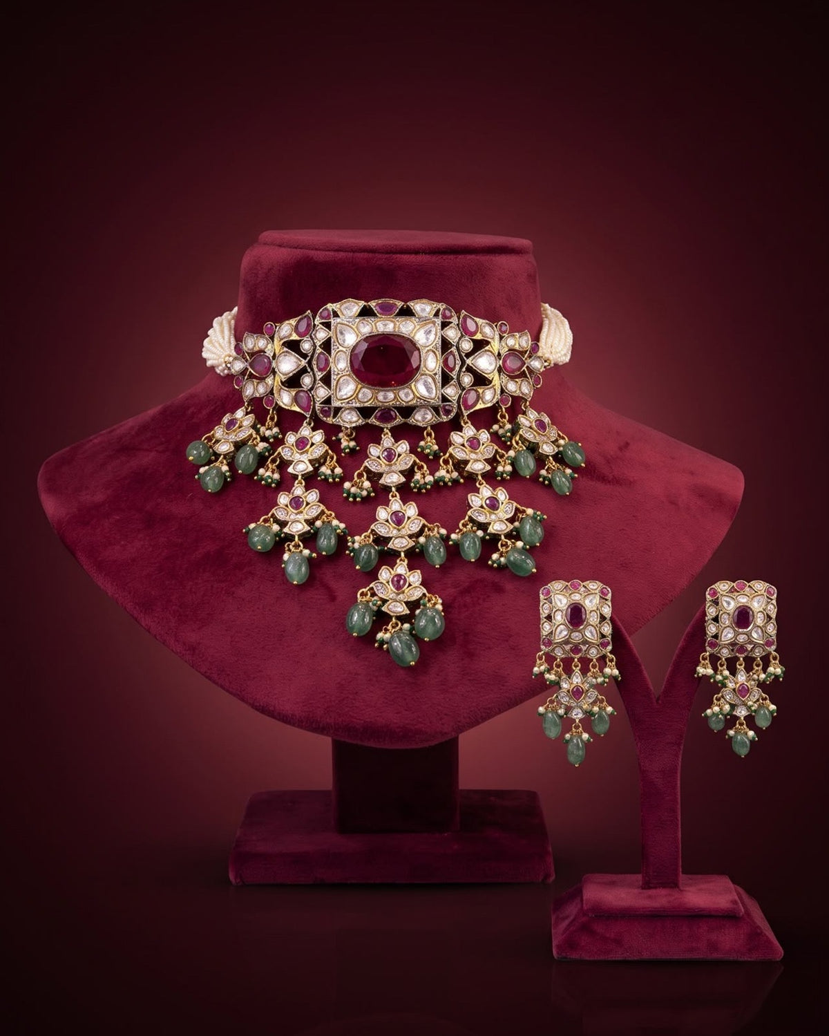 Elegant Kundan and Polki bridal choker necklace set with ruby-red stones, green beads, intricate gold detailing, matching statement earrings, and a luxurious traditional Indian design.
